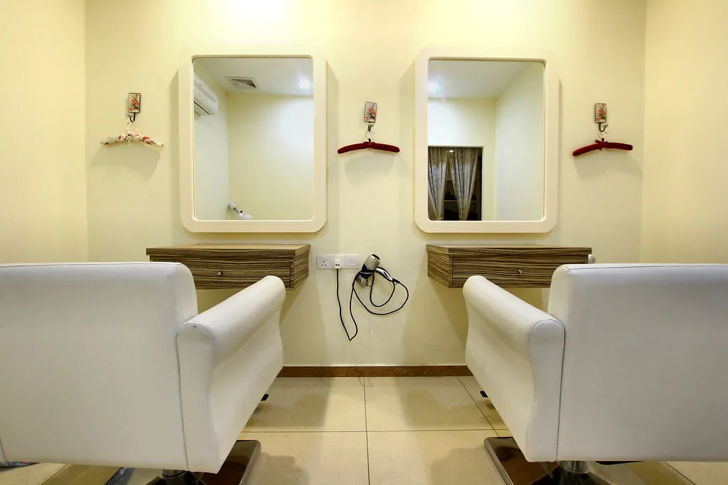 Dos sillones blancos de peluquería frente a espejos redondeados